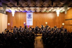 Ein Konzert der Stadtkapelle Wernau im Landkreis Esslingen, das ein volles Auditorium zeigt. Musiker in eleganter Kleidung spielen verschiedene Instrumente auf der Bühne, während die Zuschauer begeistert zuhören. Ideal für Musikliebhaber im Raum Stuttgart und Esslingen.