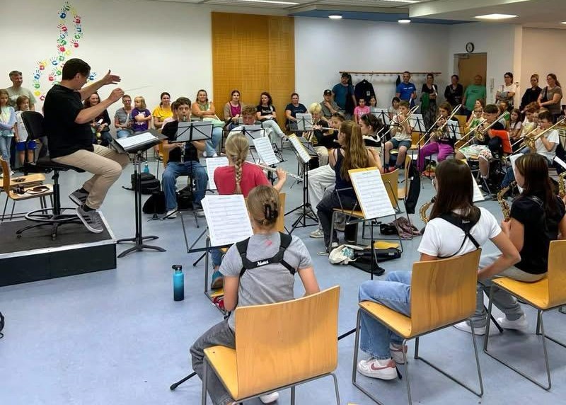 Probe der Stadtkapelle Wernau mit jungen Musikern und Musikern in einem Probenraum, um Musikinteresse im Raum Esslingen und Stuttgart zu fördern und die lokale Musikkultur zu stärken.