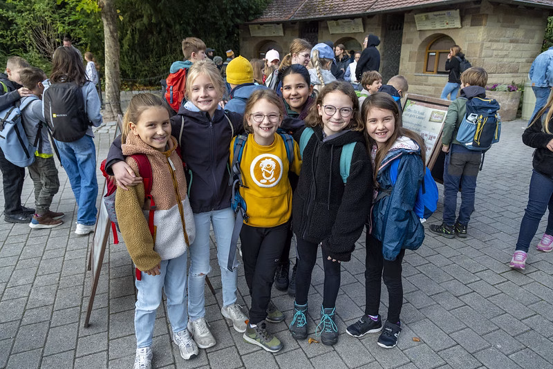 Grupp von musikbegeisterten Kindern der Stadtkapelle Wernau, die fröhlich vor einem Veranstaltungsgebäude posieren. Die Aufnahme zeigt die Verbundenheit zur Musik und das Engagement für musikalische Aktivitäten im Raum Esslingen und Stuttgart. Ideal für die Ansprache von Musikern und Musikliebhabern in der Region.